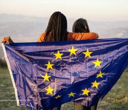 Image of two people holding an EU flag